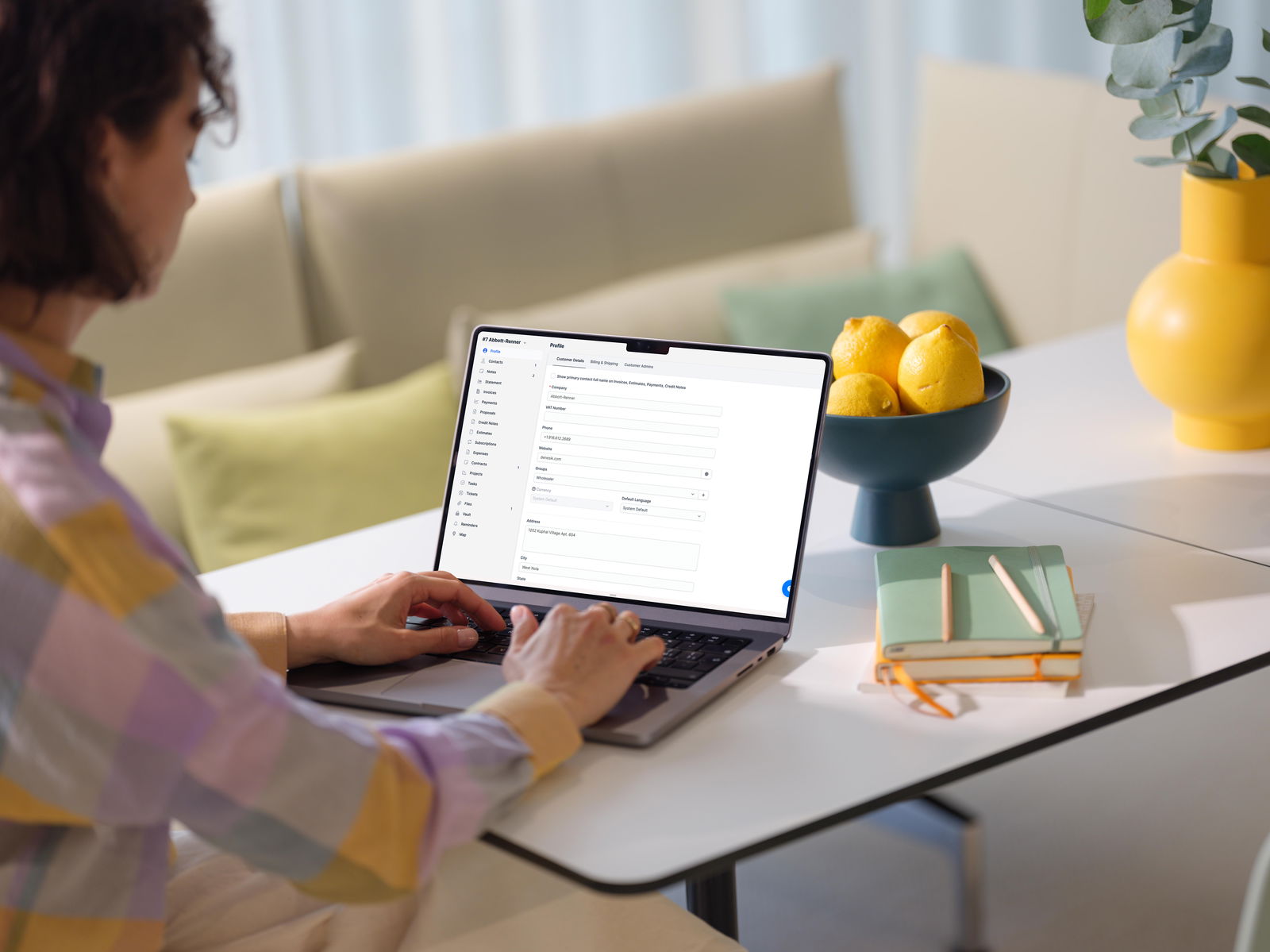 CRM platform design shown on MacBook Pro in modern home office setting